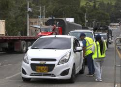 Integrantes de la Dirección de Impuestos y Adunadas Nacionales de Colombia (DIAN) hablan con una persona dentro de un vehículo este jueves, en el zona fronteriza de Colombia con Ecuador en Rumichaca.