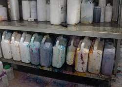 Fotografía que muestra varios envases en repisas, almacenados de forma inadecuada.