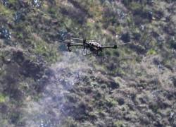 Fotografía de un dron forestal Agras T20, de tecnología china, lanzando 20.000 semillas de especies nativas que apuntan a recuperar la cobertura vegetal del árido y erosionado cerro Casitagua, afectado en parte por un incendio el año pasado, el 02 de mayo de 2024 en Quito (Ecuador).