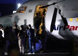 Un migrante ecuatoriano, con las manos esposadas, sube a un avión durante un vuelo de deportación de migrantes a Ecuador.