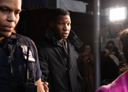 El actor estadounidense Jonathan Majors (centro) abandona una sala del tribunal tras ser declarado culpable de agresión y acoso a su exnovia, en los tribunales penales de Manhattan, en la ciudad de Nueva York, el 18 de diciembre de 2023.