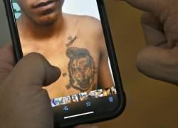 El coronel Roberto Santamaría, jefe de la unidad policial Nueva Properina en Guayaquil, muestra imágenes de tatuajes encontrados en teléfonos móviles incautados en operativos policiales.