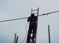 Colaborador de CNEL durante un trabajo de mantenimiento y cambio de cable, en una foto de archivo.