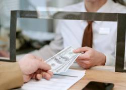 Una persona recibe dinero en una institución financiera.