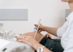 Un médico realiza un ultrasonido a una mujer embarazada.