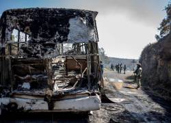 El Ejército de México inspecciona vehículos presuntamente incendiados por miembros del crimen organizado.