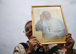 Una mujer sostiene un retrato del papa Francisco mientras asiste a una misa por su recuperación.