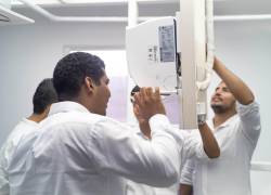 Un grupo de jóvenes capacitados en el programa LG Inverter Academy realizan trabajos en un aire acondicionado.