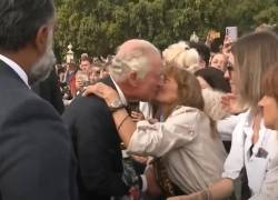 Una mujer besa al rey Carlos.