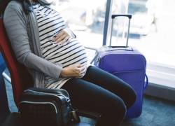 Fotografía referencial que muestra a una mujer embarazada esperando en un aeropuerto.