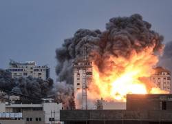 una bola de fuego y humo se eleva sobre un edificio en la ciudad de Gaza, este 7 de octubre de 2023 durante un ataque aéreo israelí.