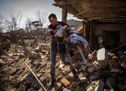 Un hombre recoge ropa de una casa dañada en la ciudad de Zhytomyr, en el norte de Ucrania, el 23 de marzo de 2022.