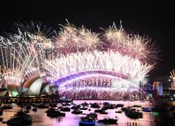 Se ven fuegos artificiales sobre la Ópera de Sídney y el Puente del Puerto durante las celebraciones de Nochevieja en Sídney, Australia, el 1 de enero de 2024.