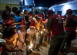 Oficiales de la Guardia del Pueblo junto a niños y vecinos del sector Petare participan en fiestas por el inicio de la temporada navideña este miércoles, en Caracas.