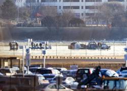 Equipos de rescate buscan entre los restos de un avión comercial que chocó con un helicóptero militar en Washington, D.C., EE.UU. Foto: EFE