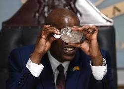 El presidente de Botswana, Mokgweetsi Masisi, observa un gran diamante descubierto en Botswana en su oficina de Gaborone el 22 de agosto de 2024.