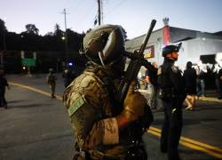 Agentes federales, incluidos miembros del Departamento de Seguridad Nacional, intentan contener a los manifestantes afuera de una instalación del Servicio de Inmigración y Control de Aduanas de Estados Unidos (ICE) en el centro de Portland, Oregón, el 6 de octubre de 2025.