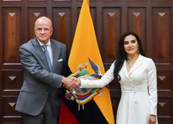 El segundo mandatario, Alfredo Borrero Vega, y la vicepresidenta electa, Verónica Abad, protagonizando un saludo frente a la bandera de Ecuador.