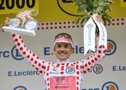 El ciclista ecuatoriano Richard Carapaz de EF Education - EasyPost celebra en el podio luciendo el maillot de lunares del mejor escalador.