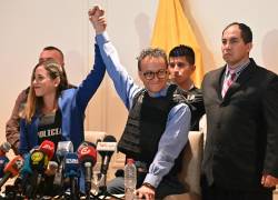 El periodista y candidato presidencial por el partido Construye Christian Zurita y su compañera de fórmula Andrea González levantan los brazos durante una conferencia de prensa en un hotel de Guayaquil.