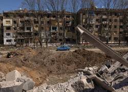 Un automóvil pasa junto a un cráter y un edificio de apartamentos dañado en Kramatorsk, región de Donetsk, Ucrania.