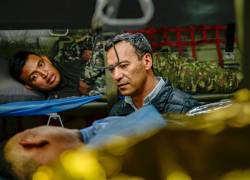 Fotografía cedida por las Fuerzas Militares de Colombia que muestra al ministro de Defensa de Colombia, Pedro Sánchez (c), visitando a heridos de un accidente aéreo este lunes.