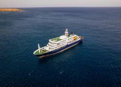 Esta fotografía aérea muestra una vista general del crucero MV Hondius anclado frente al puerto de Praia, la capital de Cabo Verde, el 3 de mayo de 2026.