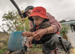 Niño y su madre lavándose las manos en los exteriores de su casa, en una zona rural de Ecuador.
