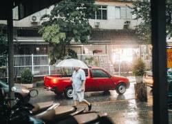 Hombre caminando bajo la lluvia por la ciudad.