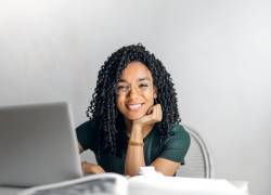 Joven posando mientras realiza estudios online.