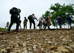 Foto referencial de migrantes que suben una colina al llegar al Centro de Recepción Temporal de Migrantes en Lajas Blancas, en el paso del Darién, en Panamá.