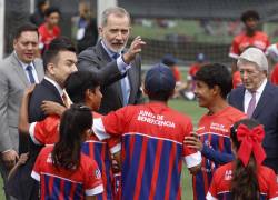 El rey Felipe VI habla niños en la inauguración de una nueva escuela del Atlético de Madrid este jueves, en Cuenca.