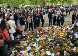 Personas miran las ofrendas de flores colocadas en Green Park, Londres, como tributo por el funeral de la reina Isabel II.
