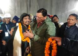 Esta fotografía publicada por el Departamento de Información y Relaciones Públicas (DIPR) de Uttarakhand y tomada el 28 de noviembre de 2023 muestra a un trabajador de la construcción (frente 2L) interactuando con el Ministro Principal de Uttarakhand, Pushkar Singh Dhami (D), luego de su rescate.