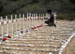 A worker paints graves for unidentified victims of the June 24 earthquake at La Esperanza Cemetery in Catia La Mar, La Guaira state, northeast of Caracas, on July 5, 2026. Venezuela's devastating twin earthquakes killed nearly 3,000, updated official figures showed on July 4, as international rescue teams began winding down search operations for survivors in the rubble of the disaster. (Photo by Miguel MEDINA / AFP)
