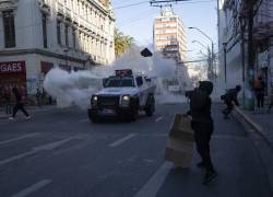 Un manifestante huye de los tanques de agua para disipar tumultos, durante una nueva jornada de protestas en Chile.