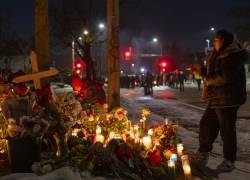 Personas participan en una vigilia en el lugar donde una mujer murió tras recibir disparos de agentes del Servicio de Inmigración y Control de Aduanas (ICE, en inglés) de Estados Unidos, este miércoles, en Minneapolis (Estados Unidos). EFE/ Angel Colmenares