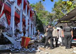 Agentes de policía observan un edificio del Comité Nacional de Deportes de Indonesia (KONI) en Sumatra del Norte que resultó dañado.