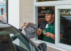Un empleado de Sweet &amp; Coffee entrega un pedido en el formato Drive&amp;Coffee.
