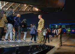 Militares estadounidenses observan a migrantes ecuatorianos que fueron deportados de Estados Unidos con destino a Ecuador.