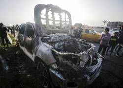 La gente se encuentra cerca de un automóvil destruido de la ONG World Central Kitchen (WCK) a lo largo de la carretera Al Rashid, entre Deir Al Balah y Khan Younis en el sur de la Franja de Gaza.