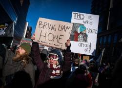 Personas sostienen pancartas en referencia a Liam Conejo Ramos, un niño de cinco años que fue retenido por agentes de inmigración.