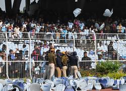 Los aficionados lanzan sillas mientras el delantero argentino número 10 del Inter de Miami, Lionel Messi, sale del Estadio Salt Lake en Calcuta.