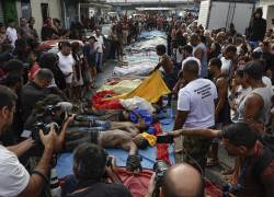 Personas observan cuerpos sin vida en una calle este miércoles, en Río de Janeiro (Brasil).