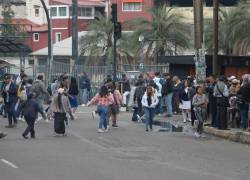 Ciudadanos esperan cerca de paradas de buses, en medio de la restricción de la circulación de unidades.