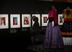 Un visitante mira los retratos fotográficos de la fallecida artista mexicana Frida Kahlo junto a los atuendos que le pertenecieron, durante una vista previa de la exposición Frida Kahlo, más allá de las apariencias en el Palais Galleria de París. (Photo by Emmanuel DUNAND / AFP)