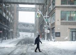 Un hombre camina sobre la nieve mientras la tormenta en Nueva York.