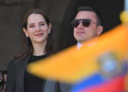 El presidente reelecto de Ecuador, Daniel Noboa (der.), y su esposa, Lavinia Valbonesi, hacen un gesto desde un balcón del Palacio Presidencial de Carondelet.