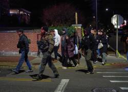 Agentes del orden escoltan a estudiantes cerca del edificio de ingeniería Barus &amp; Holley en el campus de la Universidad de Brown en Providence.