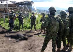 Integrantes del Ejercito de Ecuador observan el cuerpo de un presunto guerrillero dado de baja.